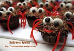 cupcakes decorated with googly eyes and red ribbons on a white tray for halloween