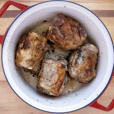 some meat in a pot on a wooden table