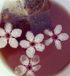 a bowl filled with soup and flowers on top of it