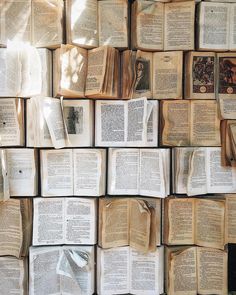 many open books are stacked on top of each other in the shape of a wall