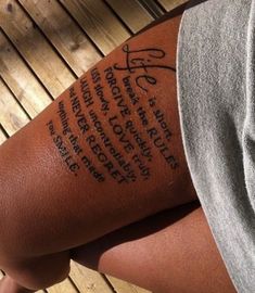 a person with a tattoo on their arm that has writing on the back of his leg