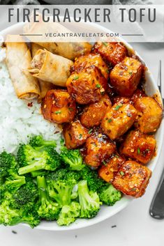 a white plate topped with chicken and broccoli next to rice on a table