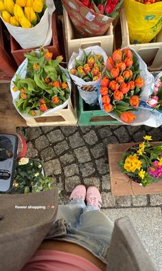 there are many different types of flowers on display at the market, including orange and yellow tulips