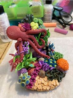 an octopus figurine sitting on top of a pile of seaweed and corals