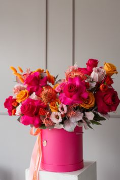 a pink hat box with flowers in it