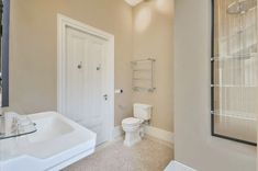 a bathroom with a sink, toilet and shower stall in the middle of the room