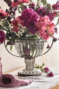 a vase filled with lots of flowers on top of a table