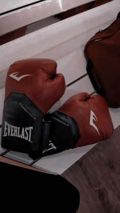 two boxing gloves sitting next to each other on the floor in front of a bench