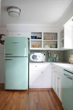 a green refrigerator freezer sitting inside of a kitchen