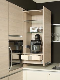 an open cabinet in a kitchen with stainless steel appliances