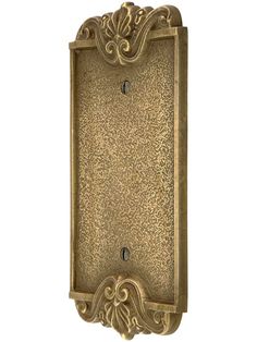 an antique brass finish wall plaque with ornate scrolls and scroll designs on the front side