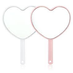 two heart shaped mirrors sitting side by side on top of each other, one pink and the other white