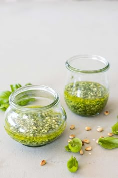 two glass jars filled with pests on top of a table