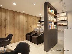 a salon with wooden walls and black chairs