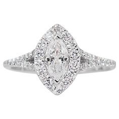 a white gold ring with a pear shaped diamond in the center and pave set shoulders