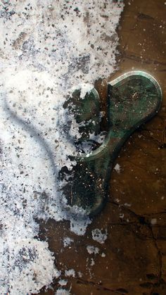 a pair of green shoes covered in snow