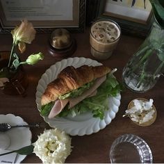 a table topped with plates filled with food and flowers next to a vase full of flowers