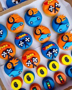 the cupcakes are decorated with racing cars and numbers on them in an open box