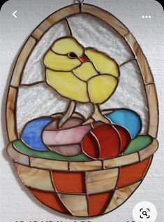 a stained glass bird sitting in a basket