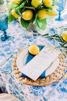 a blue and white table setting with lemons