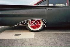 an old car with spider web on the front tire