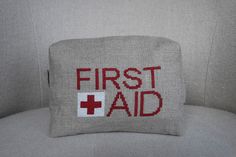 the first aid pouch is embroidered onto the back of a couch cushion, which reads'first aid '