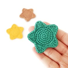 crochet stars are being held in the palm of someone's left hand