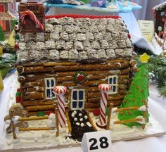 a gingerbread house decorated with candy canes and candies on a white table