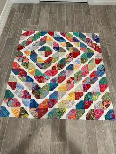 a multicolored patchwork rug on the floor in a room with hardwood floors