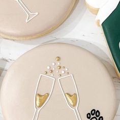 two decorated cookies with champagne glasses on them