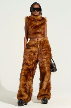 Haters will be furr-ious when they see you rocking The AKIRA Label Wild Child Cropped Fur Vest. This editorial top is crafted from impossibly soft faux fur and features a cropped, sleeveless silhouette, a slick satin inner lining, and a concealed front zipper closure. Style with the complementary Jodie Wide Leg Fashion Fur Pant for a luxe look from head to toe.  - Main: 80% Acrylic, 20% Polyester, Lining: 95% Polyester, 5% Spandex - No Stretch- Imported (all measurements approximate from size small) - 18” Shoulder to Hem- 15” Shoulder to Shoulder- Model is 5’8” and wearing a size smallProduct ID: 437733 Afrofuturism Fashion, Tracee Ellis Ross Fashion, Fall Streetwear, B Fashion, Tokyo Fashion, Wild Child, Fur Vest, Alternative Fashion, See You