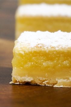 two pieces of yellow cake sitting on top of a wooden table next to each other