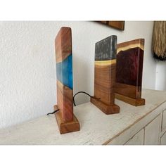 three pieces of wood sitting on top of a counter next to a wall mounted clock