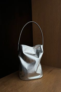 Silver leather bucket bag featuring a scrunch silhouette and tall top handle. Inside features tie strap for closure and is lined with cotton. Fit True to size Composition 100% Leather (Outer) 100% Cotton (Inner) This product is final sale Round Bucket Bag, Silver Pouch Bag, Mood Inspiration, Leather Basket, Barrel Bag, Leather Bucket Bag, Leather Bucket, Basket Bag, Nylon Bag