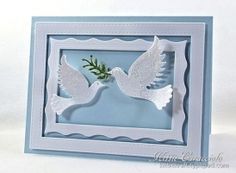 a card with two white doves and a green twig in the middle, on a light blue background