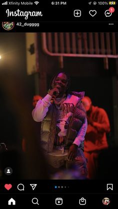 a man standing on top of a stage holding a microphone