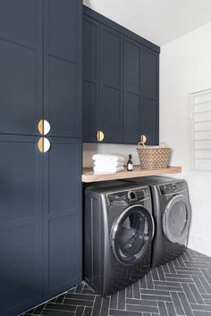 a washer and dryer in a laundry room with blue cabinets on the wall