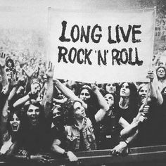 a group of people holding up a sign that says long live rock'n'roll