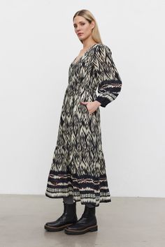 Crafted from soft viscose with a vibrant ikat print. This double-layered dress features a flattering v-neckline, a 3-button front, and tiered design, along with 3/4 sleeves and elastic cuffs for a perfect fit. Complete with side seam pockets, it effortlessly blends elegance with practicality. Casual Long Sleeve Dress With Ikat Print, Casual Long Sleeve Ikat Print Dress, Spring V-neck Ikat Print Dress, Velvet Tees, Cami Shirt, Boho Midi Dress, Dress Velvet, Layered Dress, Ikat Print