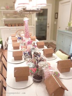 the table is set up for a party with gingerbread houses and candy canes