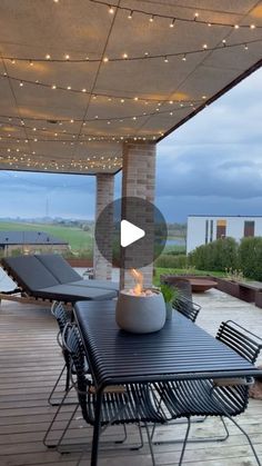 an outdoor patio with lights on the ceiling and tables set up for dinner or conversation