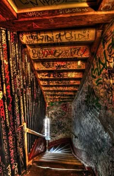 graffiti is painted on the walls and ceiling in an alleyway with stairs leading up to it