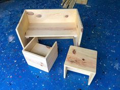 three pieces of wood sitting on top of a blue floor