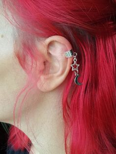 a woman with red hair and piercings on her ear