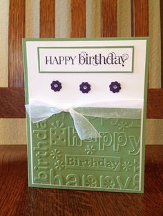 a happy birthday card with flowers on the front and back, sitting on a wooden table