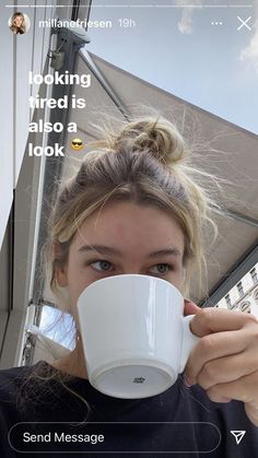 a woman holding a coffee cup up to her face