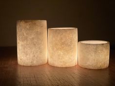 three lit candles sitting on top of a wooden table