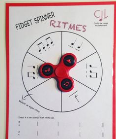 a red fidget spinner sits on top of a sheet of paper with music notes