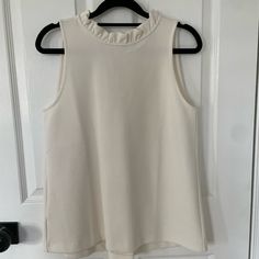 Beautiful Ann Taylor Navy Blue Sleeveless Top With V In The Back And Pleating. I Am Also Selling In Navy - They Are Gorgeous And I Am Hesitant To Part With Them But I Haven’t Worn Them Yet And Need To Declutter. Very Substantial Fabric. Size Xs. Chic Cream Tank Top, Sleeveless Cream Top With Ruffles, Cream Sleeveless Top With Ruffles, Feminine Sleeveless Off White Top, White Tank Top For Workwear, White Tank Top For Work, White Stretch Tank Top With Ruffles, Chic White Tank Top For Work, Chic Cream Sleeveless Blouse Tank Top