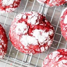 red velvet cookies cooling on a wire rack with powdered sugar sprinkled on top